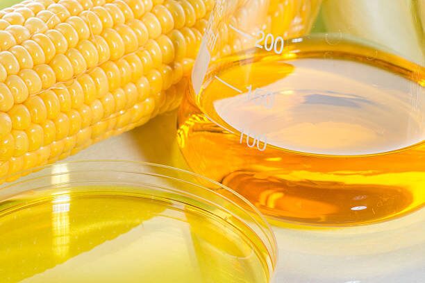 Corn near a flask with yellow liquid in it